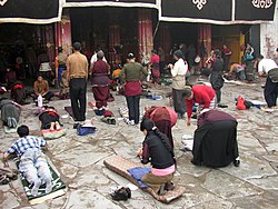 https://upload.wikimedia.org/wikipedia/commons/thumb/d/d3/Prayers_in_front_of_Jokhang_temple.jpg/250px-Prayers_in_front_of_Jokhang_temple.jpg